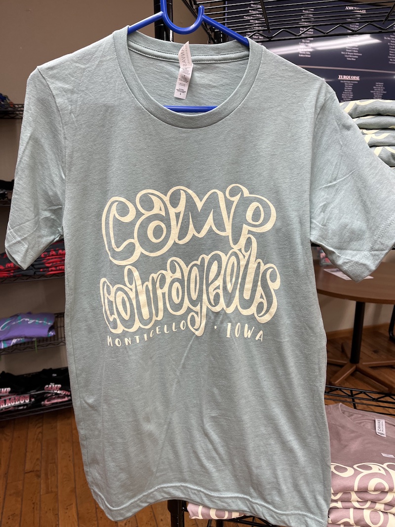 Heather prism blue t-shirt with cream colored Camp Courageous graphic.